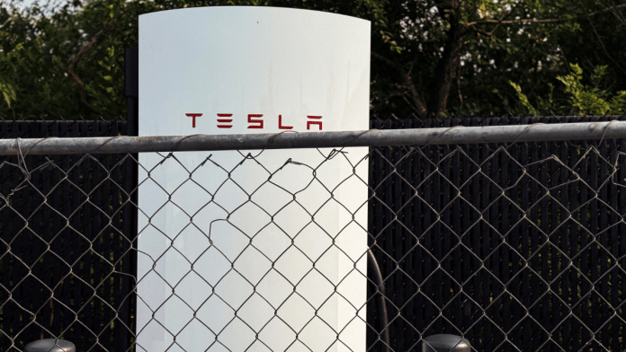A Tesla electric vehicle charging station sits behind a fence in a parking lot in New Hyde Park, New York, U.S., on 2 July 2025. | File Photo | Shannon Stapleton | Reuters
