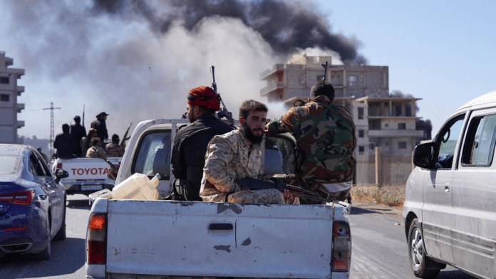 Smoke rises while Syrian security forces sit in the back of a truck as Syrian troops entered the predominantly Druze city of Sweida on Tuesday following two days of clashes, in Sweida, Syria 15 July | Reuters