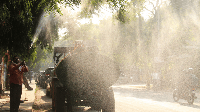 Representational image | A worker sprays water to curb air pollution | ANI