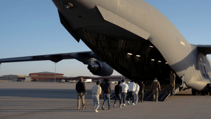 File photo of U.S. Customs and Border Protection security agents guiding detained migrants to board a U.S. Air Force C-17 Globemaster III aircraft | Reuters