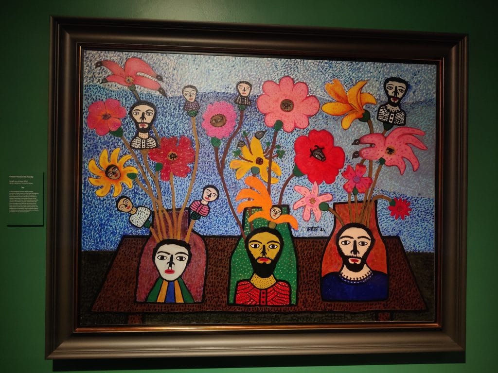 In Flower Vase in My Family, 2024, Parekh turns flower vases into family portraits, blending blooming forms with birds, bees, and hybrids against a textured sky.