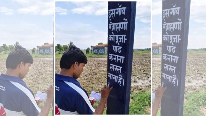 A Yadav villager paints a boycott message on a pole — Brahmins are prohibited from doing Puja in this village.