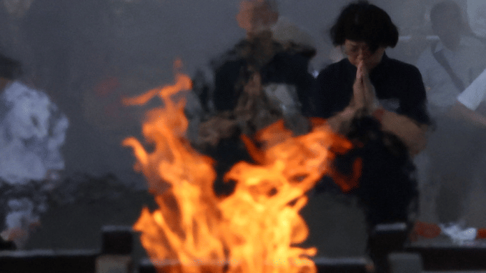 People pray at the Peace Memorial Park in Hiroshima on the 80th Atomic Bombing Day anniversary in Hiroshima, western Japan, August 6, 2025.