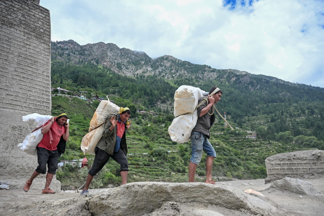Porters carry essential supplies on their backs for the villagers of Dharali | Suraj Singh Bisht | ThePrint
