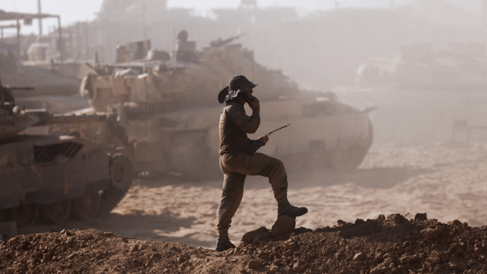 An Israeli soldier stands next to military vehicles as seen from the Israeli side of the Israel-Gaza border, Israel August 18, 2025 | File photo | Reuters