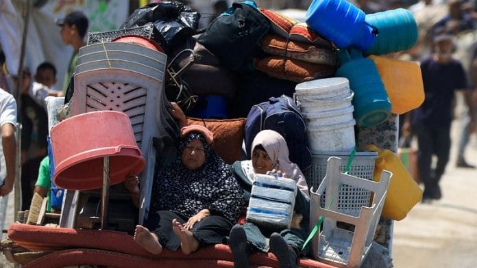 Displaced Palestinian women fleeing northern Gaza ride with their belongings as they head south, amid an Israeli military operation, in Gaza City, on 21 August 2025. | Dawoud Abu Alkas | Reuters