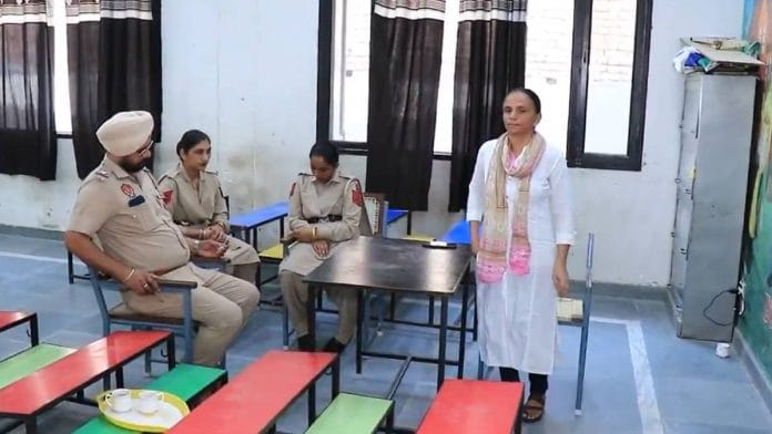 Screengrab from a video of a teacher attending to a school class in Bathinda with a police team keeping watch | X