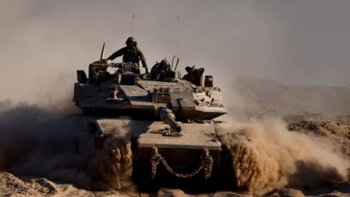 An Israeli tank manouvres at the Israel-Gaza border, as seen from Israel, August 26, 2025. | REUTERS