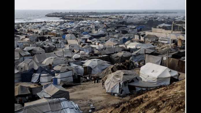 Palestinians, displaced by the Israeli offensive, shelter in a tent camp on a beach amid summer heat in Gaza City, August 12, 2025. REUTERS/Mahmoud Issa
