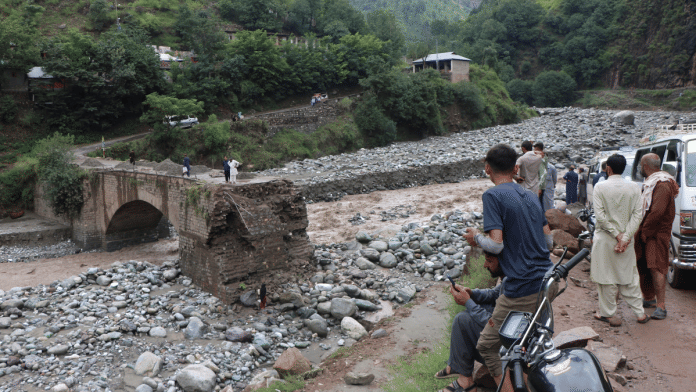 Residents gather at the site of a damaged bridge following a storm that caused heavy rains and flooding on the outskirts of Muzaffarabad, the capital of Pakistan-administered Kashmir, August 15, 2025 | Reuters