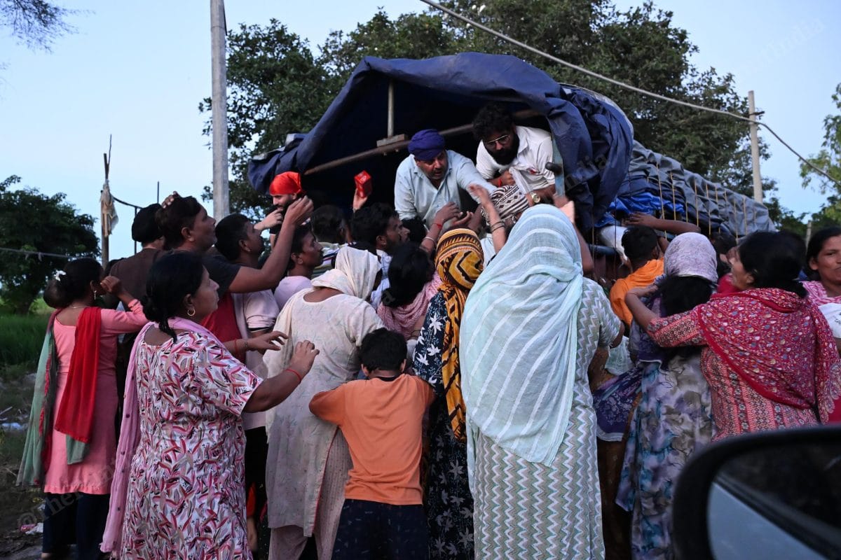 People rushed towards the tractor to collect the food and daily essential | Suraj Singh Bisht | ThePrint