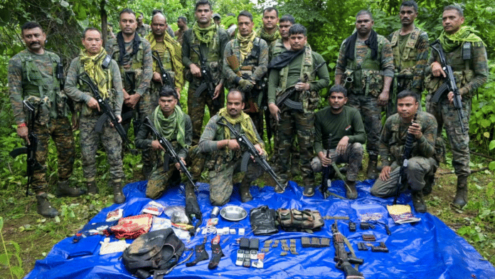 Security personnel pose with the arms, ammunition and other items recovered from maoists during a gunfight, in Palamu district, Jharkhand on 14 September 2025. | PTI