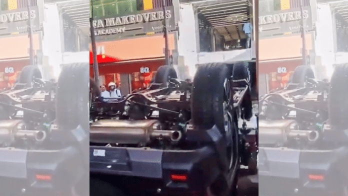 In this screengrab from a social media video received on a Thar Roxx lies overturned after accidentally falling through a Mahindra showroom window | PTI