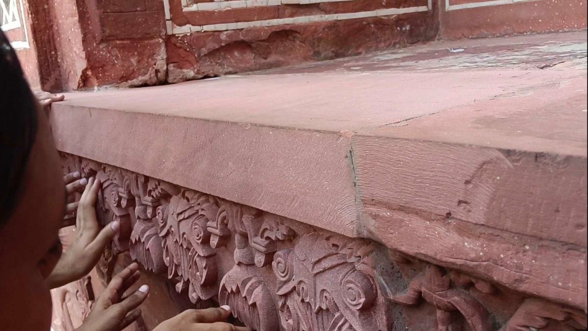 The group walks in a line, touching the walls and carvings of the Taj Mahal and other monuments within the premises| Almina Khatoon, ThePrint