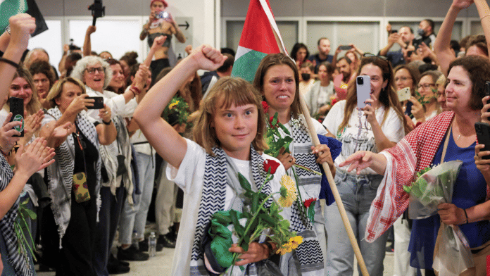 Swedish activist Greta Thunberg, who was part of the Global Sumud Flotilla seeking to deliver aid to Gaza and was detained by Israel, gestures as she is greeted by supporters upon her arrival to the Athens Eleftherios Venizelos International Airport on 6 October 2025. | Louisa Gouliamaki | Reuters