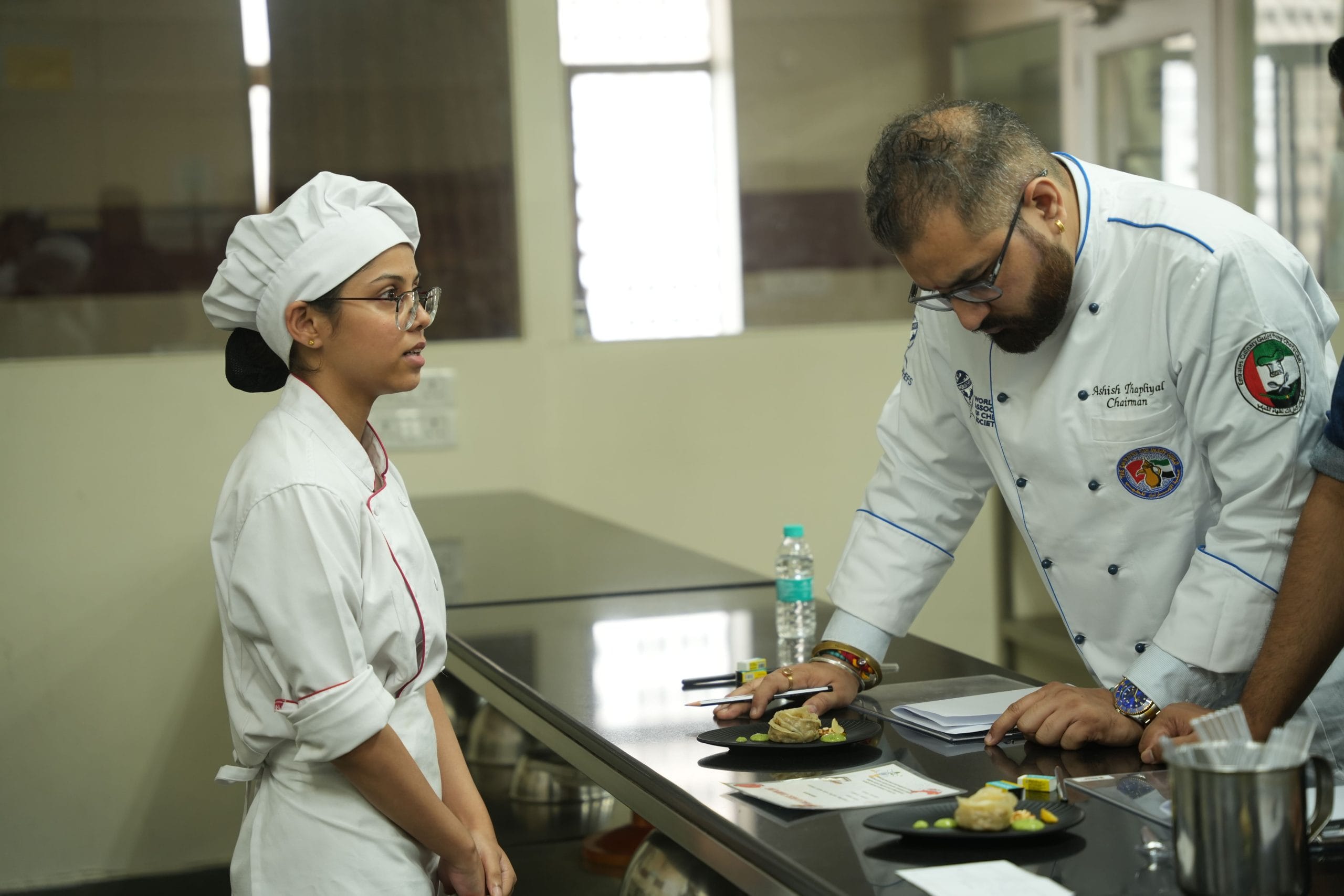 A chef grades a student's dish at the Great Indian Cultivated Chicken Cook Off