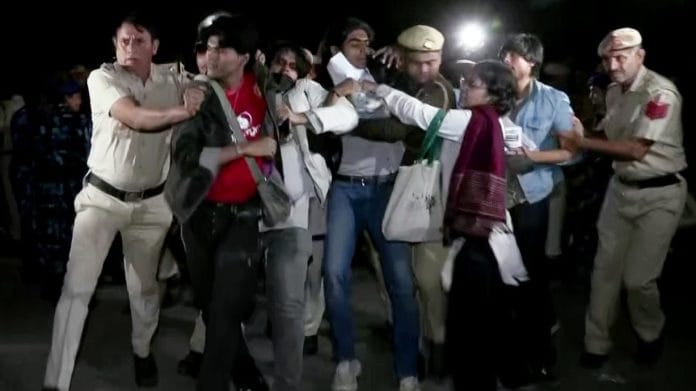 Police personnel detain protesters during the protest against rising air pollution at India Gate, in New Delhi on Sunday | ANI