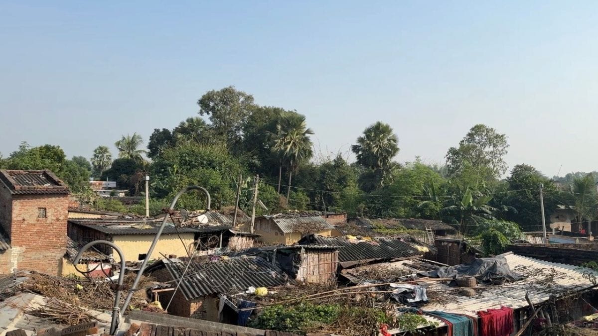A view from Dilip’s three‑storied brick house looks out at the plastic‑roofed huts. Photo: Jyoti Yadav, ThePrint 