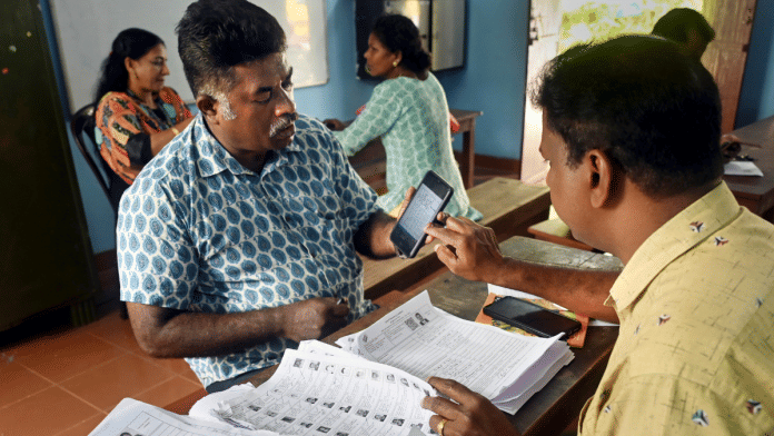 A Booth Level Officer (BLO) interacts with a voter as he checks and collects filled enumeration forms for the special intensive revision (SIR) of electoral rolls, in Thiruvananthapuram, Tuesday, Nov. 25, 2025 | Representational image | PTI