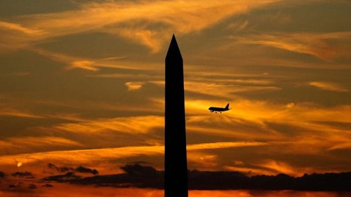 A commercial aircraft flies past the Washington Monument during a partial government shutdown in Washington, D.C., on 2 October 2025. | Nathan Howard | Reuters