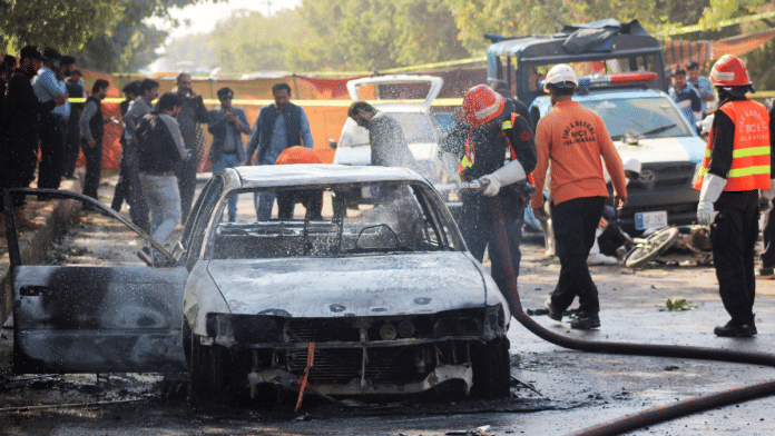 Firefighter douses a vehicle after a blast outside a court building in Islamabad | Reuters