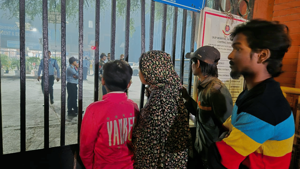 Nazma Khatoon and Mohd Chand (wearing a cap) outside the gate at LNJP Hospital on Monday night | Shubhangi Misra | ThePrint