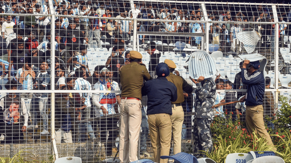 RAF and police personnel shield themselves as angry fans vandalise the Salt Lake Stadium, alleging poor management during Argentine footballer Lionel Messi's G.O.A.T India Tour | ANI 