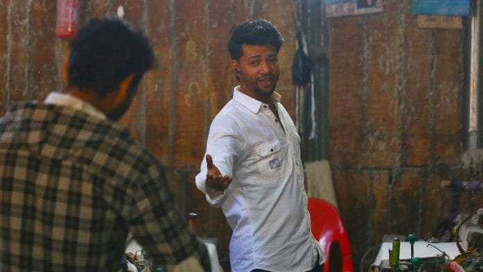 Nihal Ansari strikes a Shah Rukh Khan pose as he shoots a Reel inside a powerloom. Manisha Mondal | ThePrint