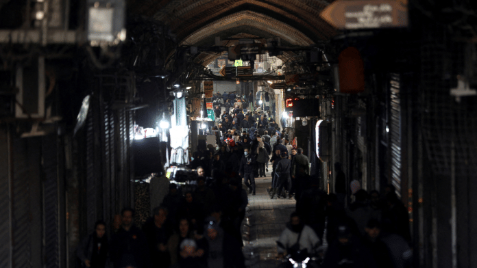 People walk past closed shops, following protests over a plunge in the currency's value, in the Tehran Grand Bazaar in Tehran, Iran on 30 December 2025 | Reuters