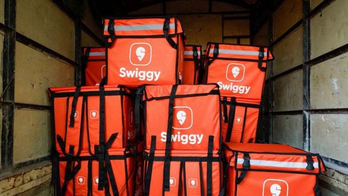Several Swiggy delivery boxes stacked one above the other in a container