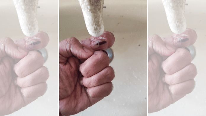 Screengrab from a video showing indelible ink being erased from nails | X