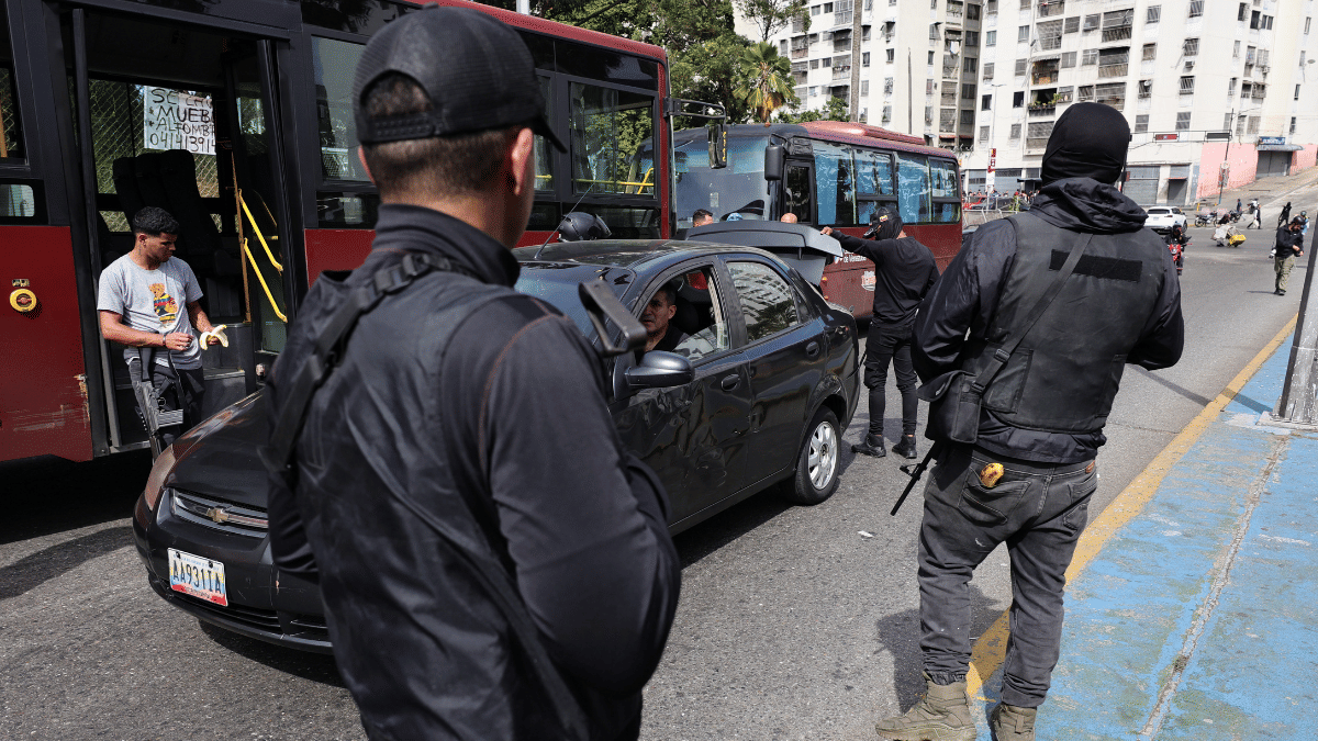 Armed men inspect a car’s trunk in Caracas, on Jan. 3. Photographer: Jesus Vargas/Getty Images via BLOOMBERG