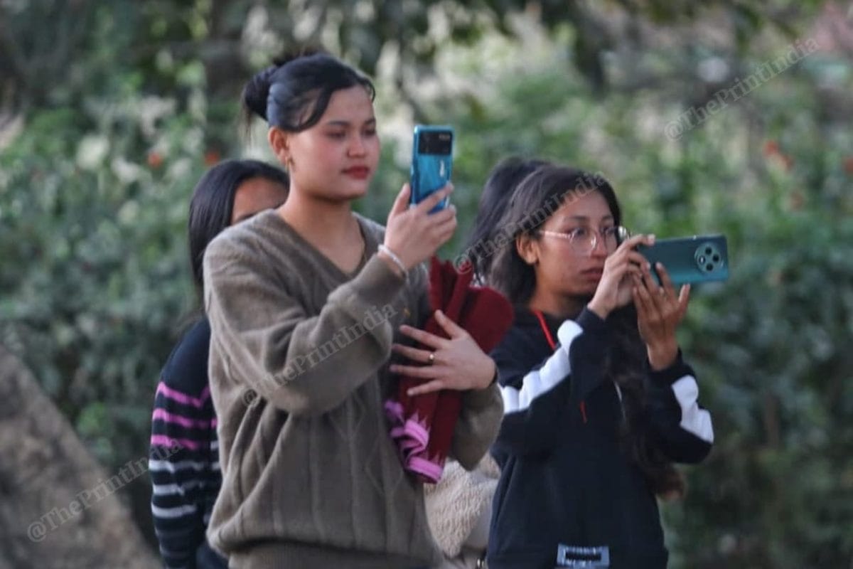 People standing on the road taking videos as M. Rishikant's body is taken from the mortuary | Praveen Jain | The Print