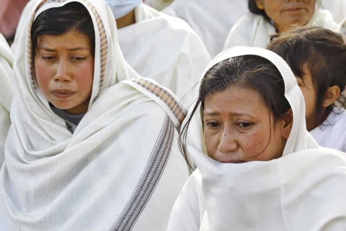 Two sisters of the victim sit at the main crossroads of the Kaching district wearing white shawls in a mark of protest against their brother's murder by the Kuki leaders | Praveen Jain | ThePrint