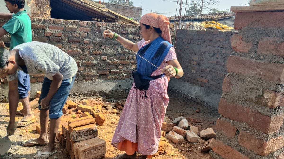 Anushka’s mother, Rita Devi, works alongside labourers as the family’s new house comes up under government support | Photo: Almina Khatoon | ThePrint