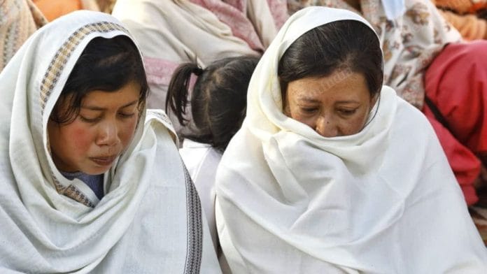 Two sisters of the victim sit at the main crossroads of the Kaching district wearing white shawls in a mark of protest against their brother's murder by the Kuki leaders | Praveen Jain, ThePrint