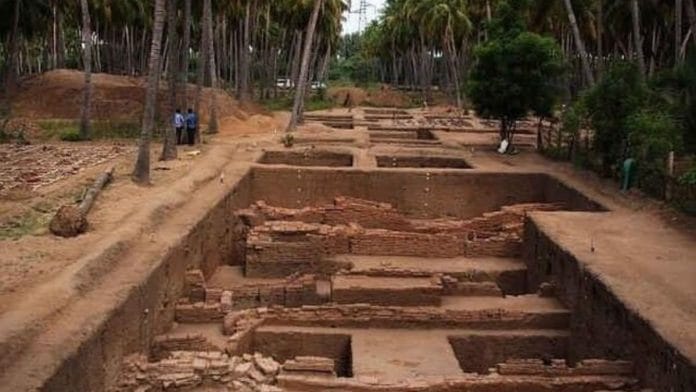 A photo of the Keeladi excavation site showing square trenches and walled structures unearthed.