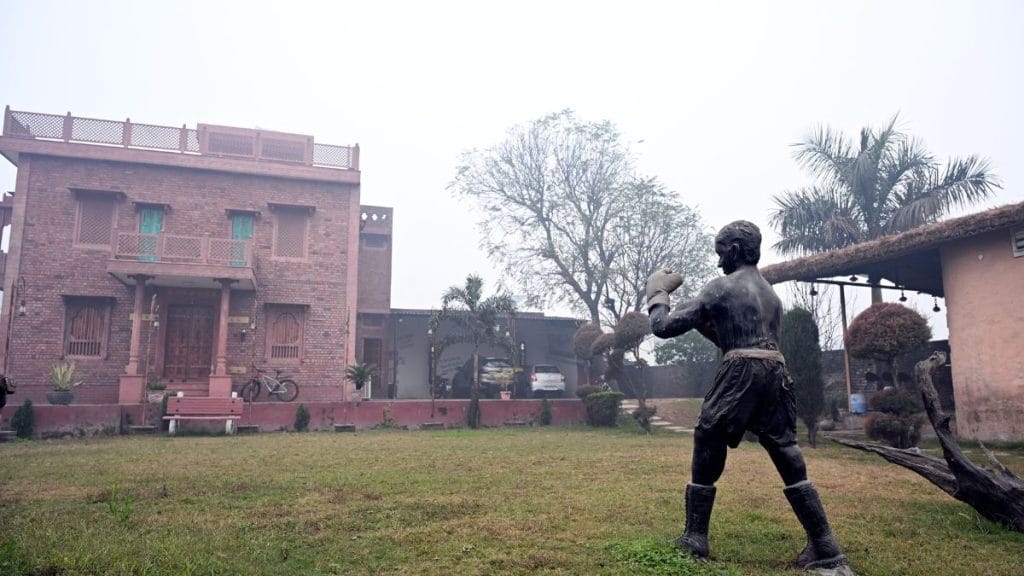 A black stone statue of a child in a boxing stance stands at the entrance of Neeraj Goyat’s house. Suraj Singh Bisht | ThePrint