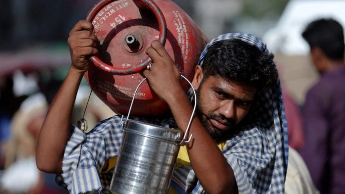 A man carries an LPG cylinder on his shoulder at a wholesale market in the old quarters of Delhi, India, June 7, 2023. | REUTERS/Anushree Fadnavis