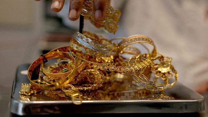 FILE PHOTO: A goldsmith weighs gold jewellery inside a showroom in Ahmedabad, India, July 31, 2025. | REUTERS/Amit Dave/File Photo