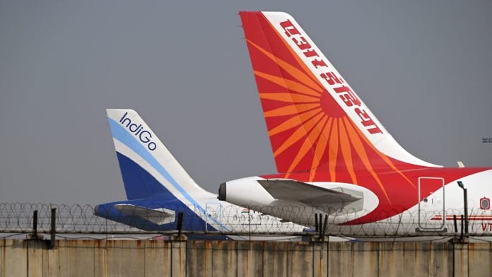 An IndiGo aircraft, operated by InterGlobe Aviation Ltd., left, and an Air India Ltd. aircraft on the tarmac at Indira Gandhi International Airport in New Delhi, India, on Tuesday, Jan. 20, 2026. | Bloomberg