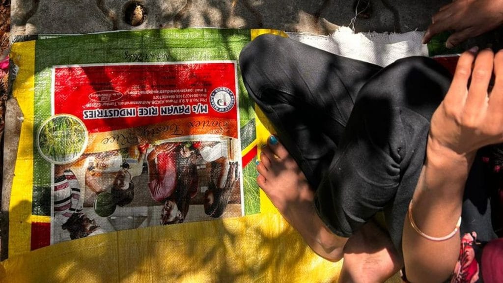 A worker sits on a mat on the concrete between gigs. Manisha Mondal | ThePrint