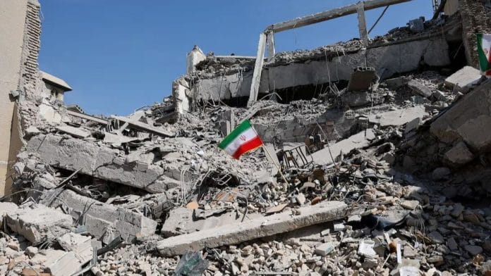 An Iranian flag stands in the rubble following a strike on a police station in Tehran, Iran, 4 March, 2026 | Asgaripour/WANA/Reuters