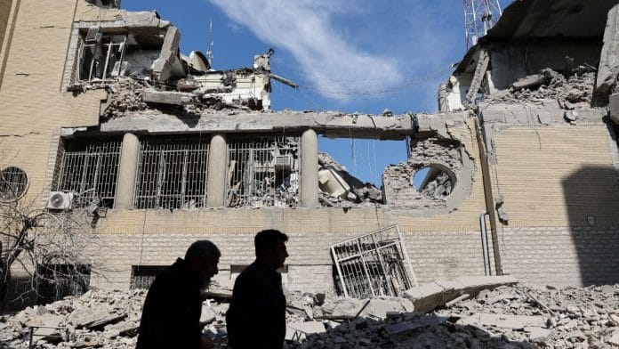 People walk past damaged buildings following a strike on a police station in Tehran on Wednesday | Majid Asgaripour | West Asia News Agency | REUTERS