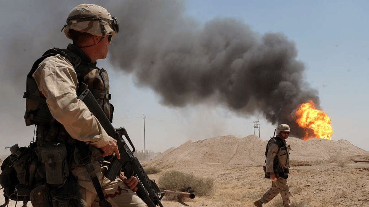 US Army Sgt. Mark Phiffer stands guard duty near a burning oil well in the Rumaylah Oil Fields in Southern Iraq | U.S. Navy photo by Photographer's Mate 1st Class Arlo K. Abrahamson