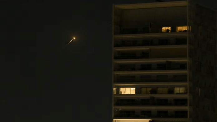 A streak of light illuminates the sky during an interception attempt made by Israel as missiles are launched from Iran, in Tel Aviv. Stay tuned for live updates | Reuters