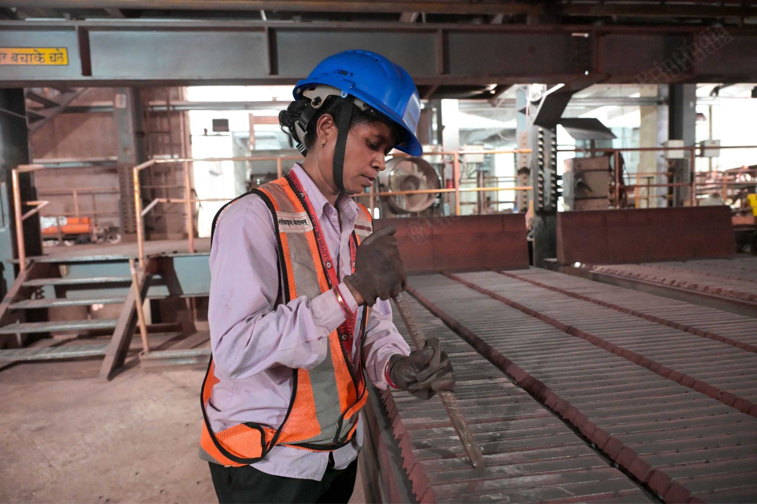 उर्मिला बुधराम लकड़ा पेलेट फैक्ट्री में मिक्सिंग मशीन की तेज़ गर्मी और आवाज़ के बीच काम करती हुईं | फोटो: सूरज सिंह बिष्ट/दिप्रिंट