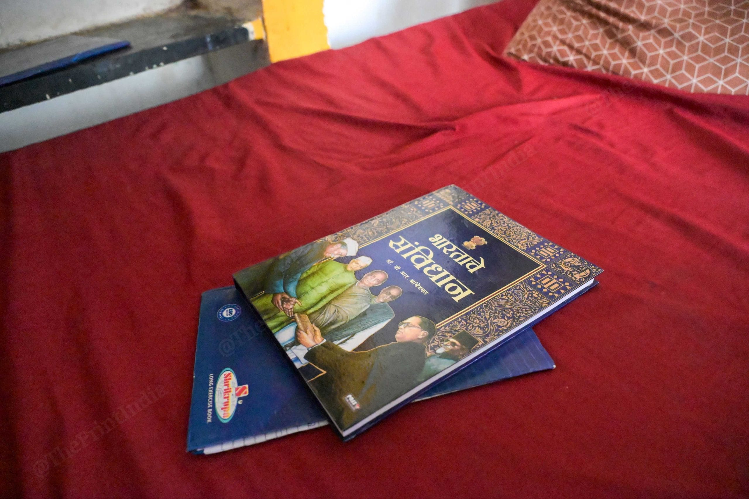 गिरिधर के कमरे के बिस्तर पर रखी संविधान की कॉपी | फोटो: सूरज सिंह बिष्ट/दिप्रिंट