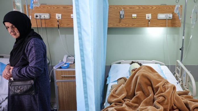 Aunt of Aline Saeed, 7, stands by the bed of Aline's mother Ghinwa (not pictured), as they are treated for injuries from the recent Israeli strike in Srifa village, which killed four members of the family, at the Jabal Amel Hospital in Tyre, Lebanon, April 11, 2026. | REUTERS/Louisa Gouliamaki