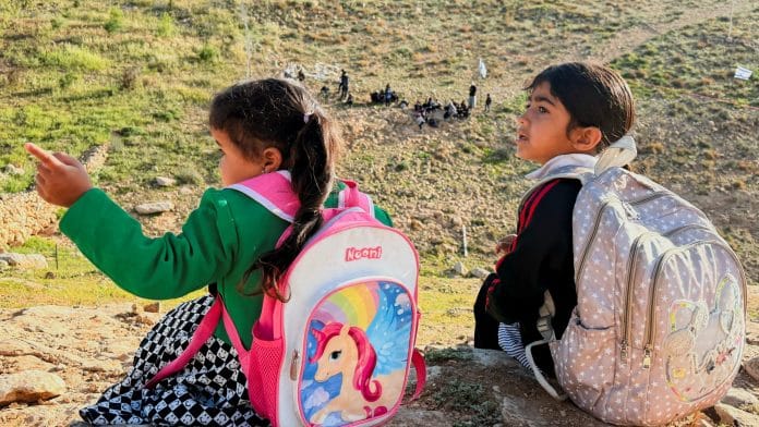 Palestinian students gather near a fence installed by Israeli settlers in their way to school, near Umm al-Khair village in Masafer Yatta, in the Israeli-occupied West Bank, April 14, 2026. Picture taken with a mobile phone. | REUTERS/Yosri Aljamal